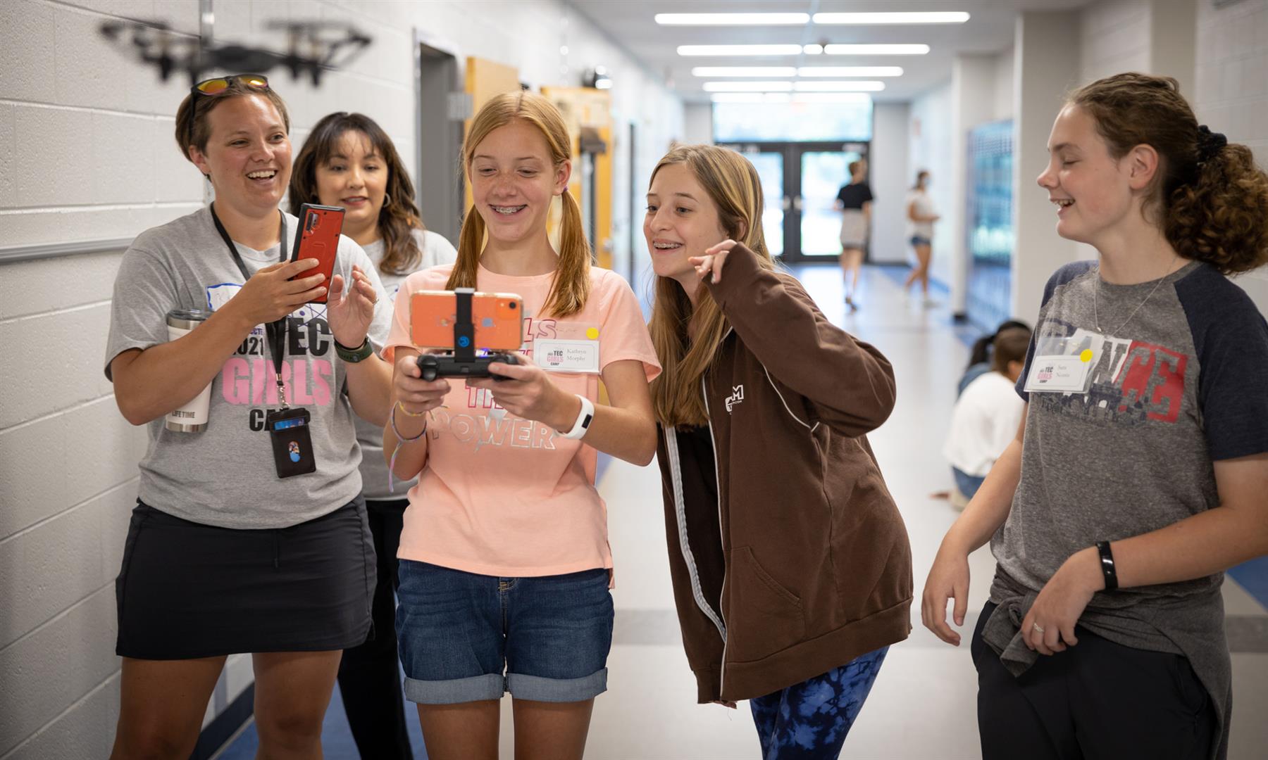 A group of students and teachers take a photo using a drone